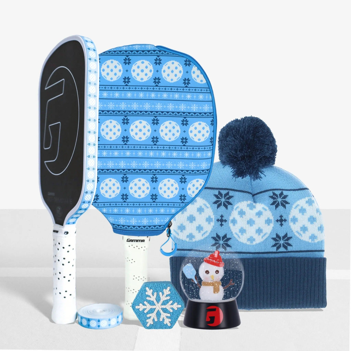 Pickleball gift bundle featuring paddles, paddle cover, winter hat, novelty dampener, and decorative snow globe accessory.