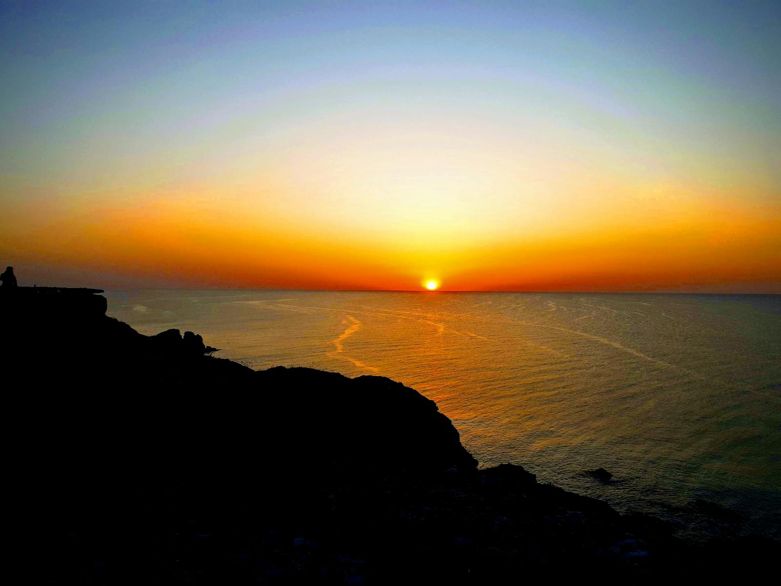 Bowler's hand gripping ball before release in pro shop light