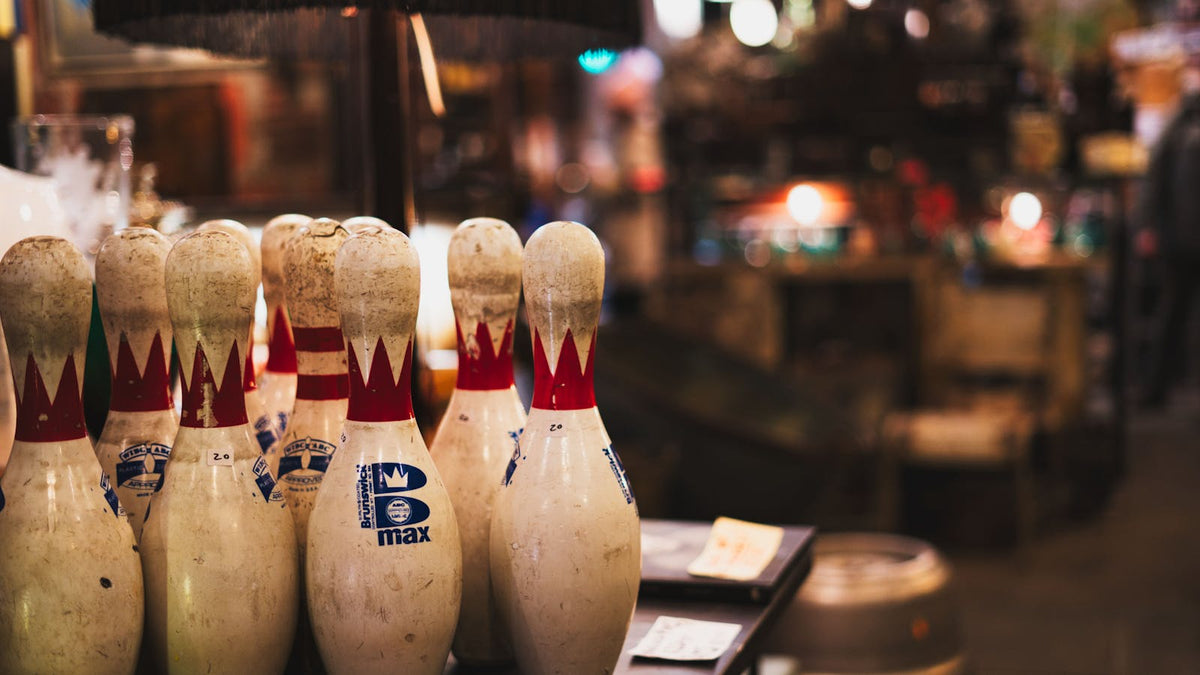 Row of vintage bowling pins under warm alley lights