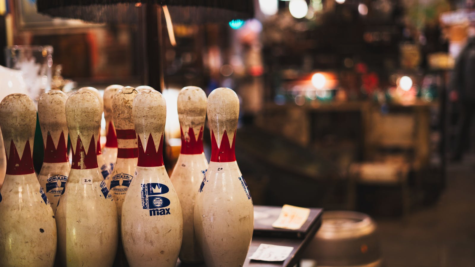 Row of vintage bowling pins under warm alley lights