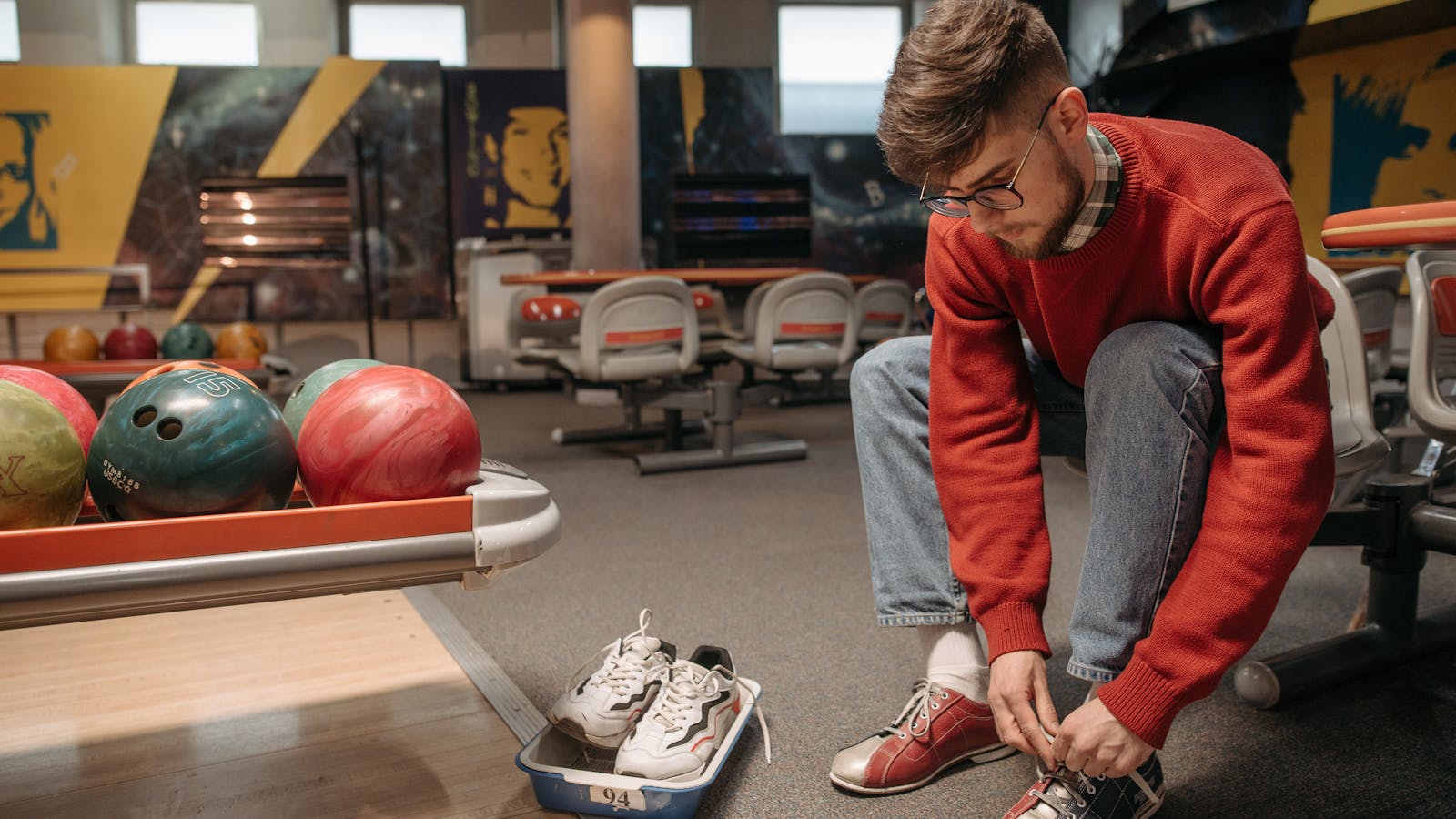 Bowler tying slide-sole shoe before the approach