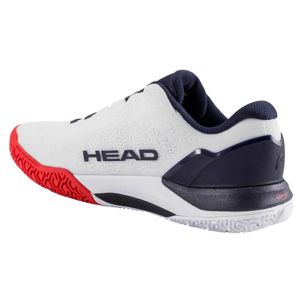 Product image of a white and navy HEAD Revolt Pro men’s tennis shoe on a black background, featuring one shoe in side profile with a breathable mesh upper, dark laces, HEAD logo, and red-accented cushioned midsole, alongside a second shoe flipped to show the red non-marking outsole with geometric traction pattern and lateral stability support.