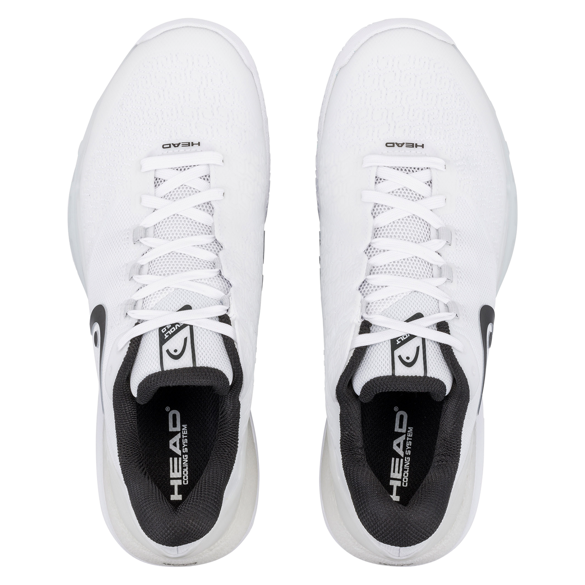 Product image of a white HEAD Revolt Pro men’s tennis shoe on a black background, showing one shoe in side profile with a breathable white mesh upper, white laces, dark HEAD logo, and cushioned midsole, alongside a second shoe rotated to display the white non-marking outsole with geometric traction pattern and central stability shank.