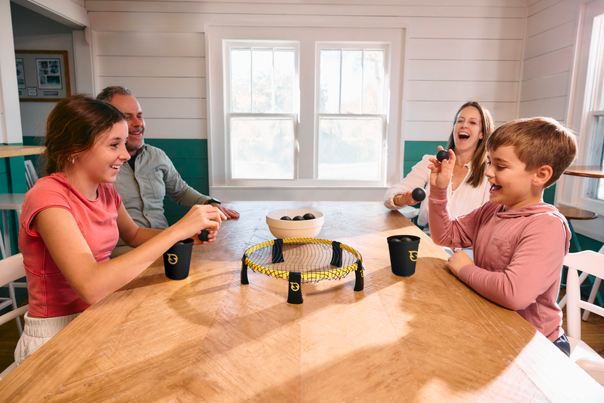 Family playing Spikeball Spikepong around a table - lifestyle view