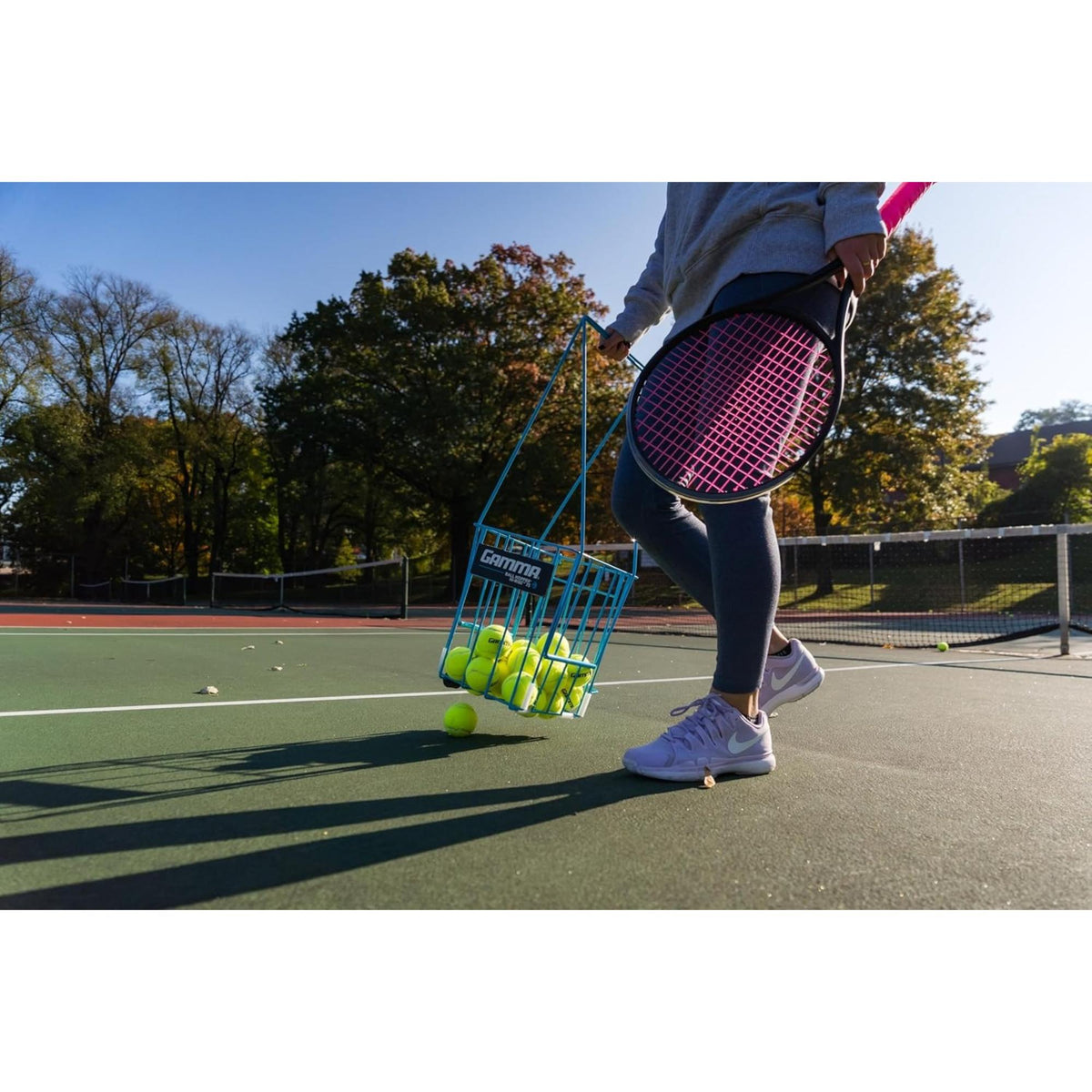 Portable tennis ball hopper basket with stand, designed for easy storage, transport, and convenient access to multiple tennis balls during practice.