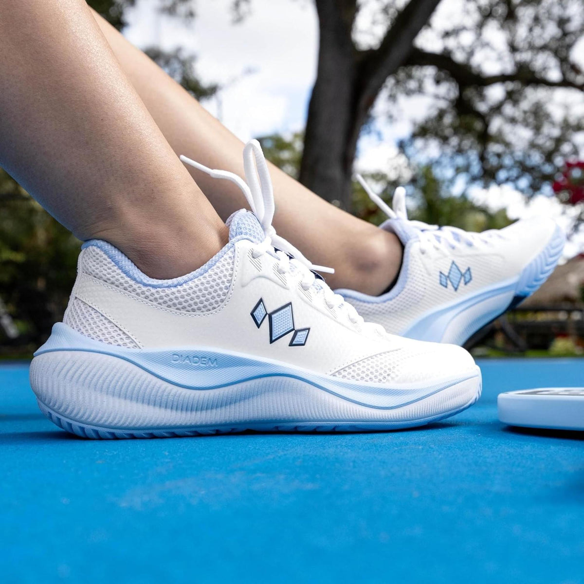 Pair of athletic court shoes with lace-up design, breathable upper, and cushioned sole for court play.