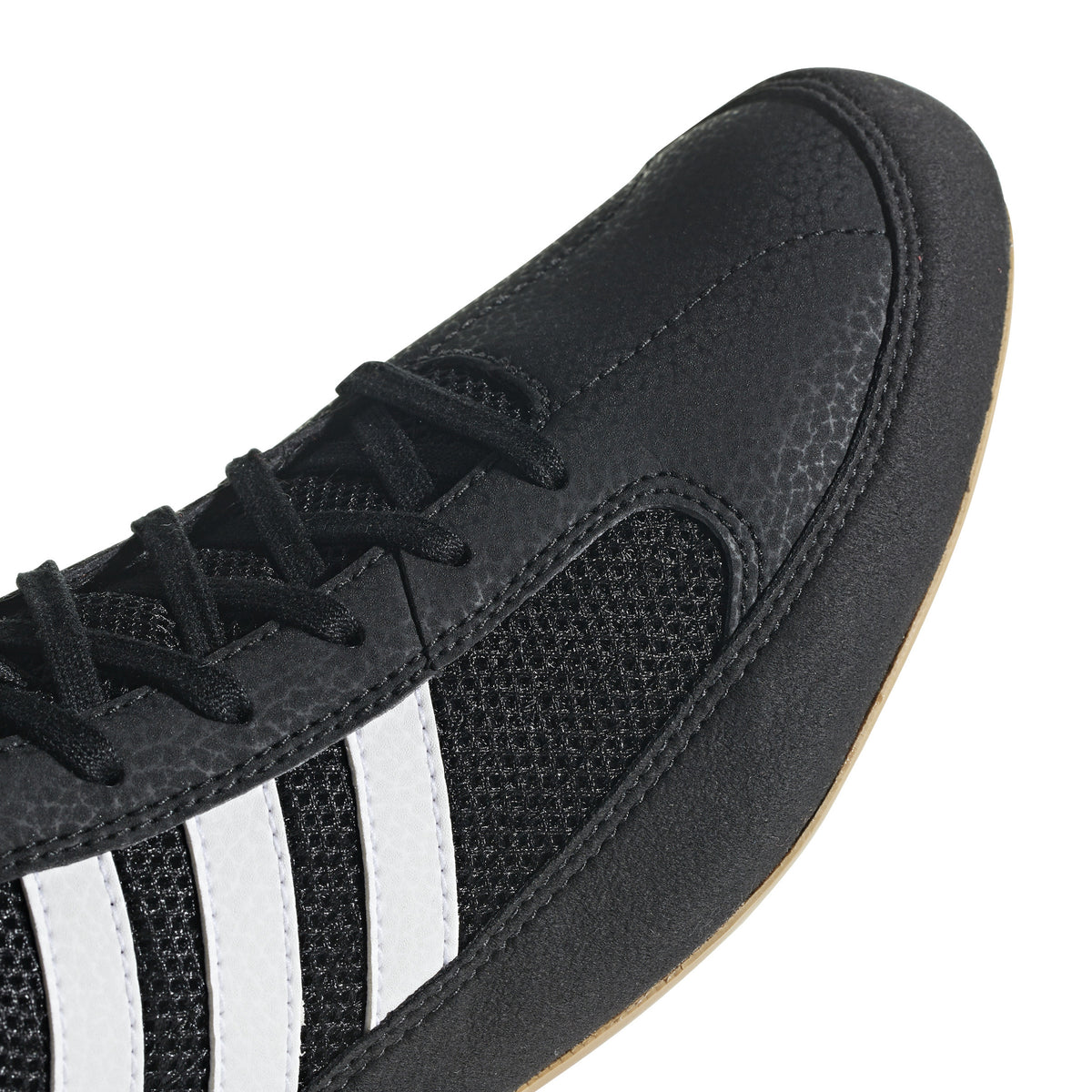 Black high-top wrestling shoe with a breathable mesh upper, black laces, padded ankle strap, and three white diagonal stripes on the side; shown from side and sole views, featuring a tan gum rubber outsole with circular traction patterns and Adidas logo for grip, stability, and mat control.