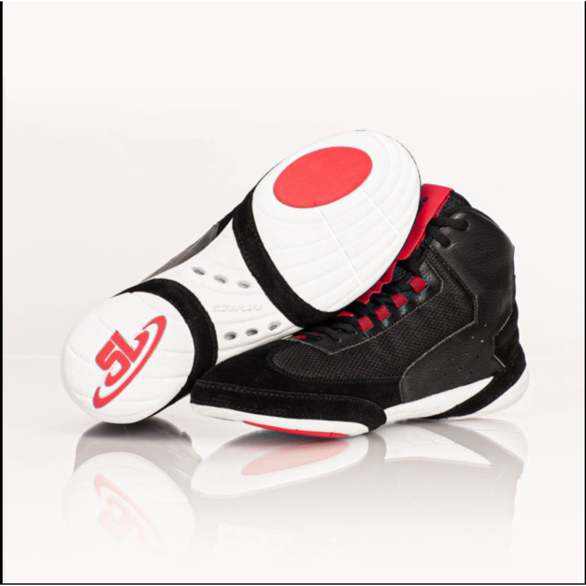 Black and white sneakers with red accents on a reflective surface