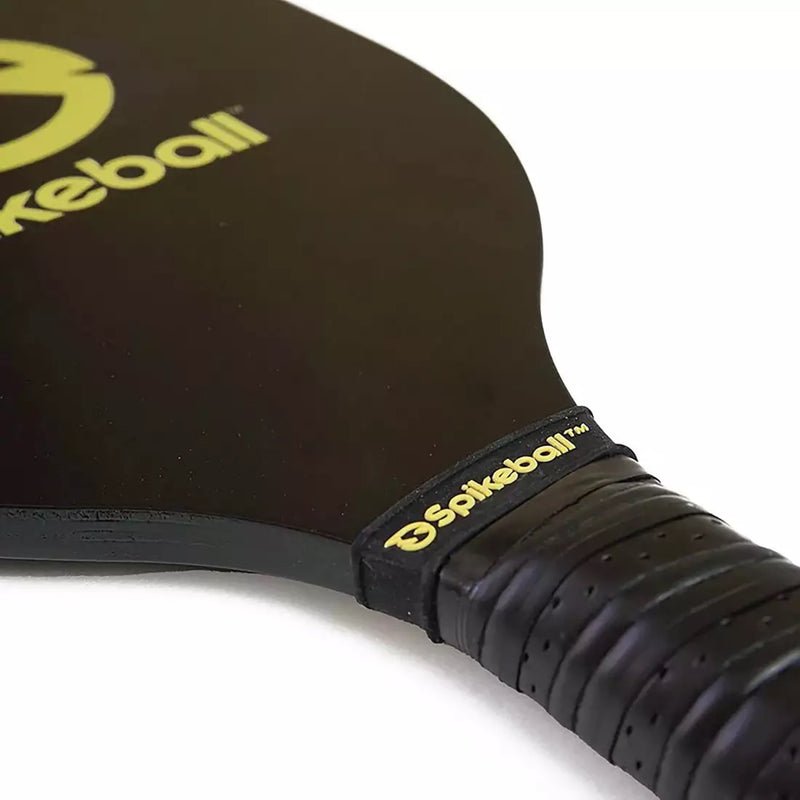 Close-up of a black pickleball paddle with yellow text on a white background