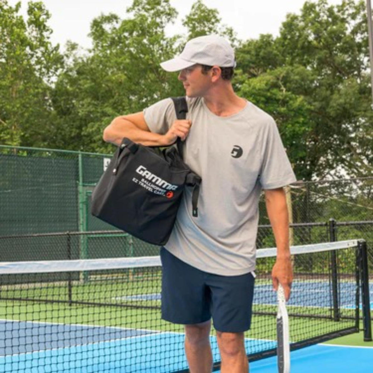 Soft-sided travel cart bag with large main compartment, carry handles, and side pockets, designed for transporting and storing balls and equipment.