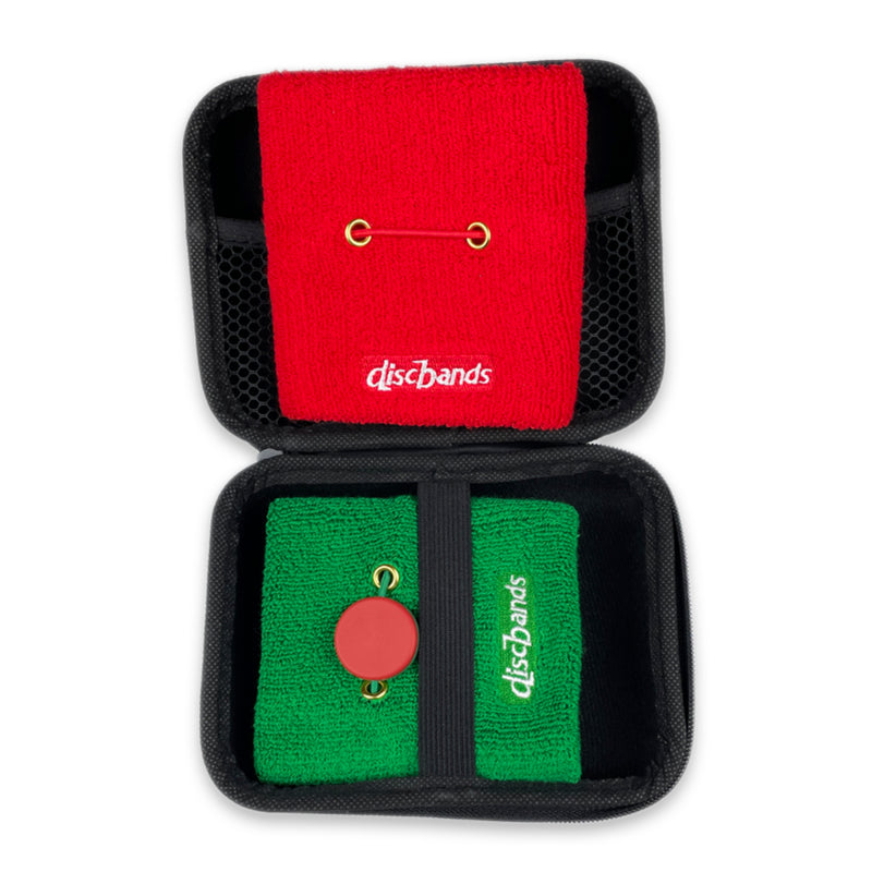 Red and green disc golf discs in a black carrying case on a white background