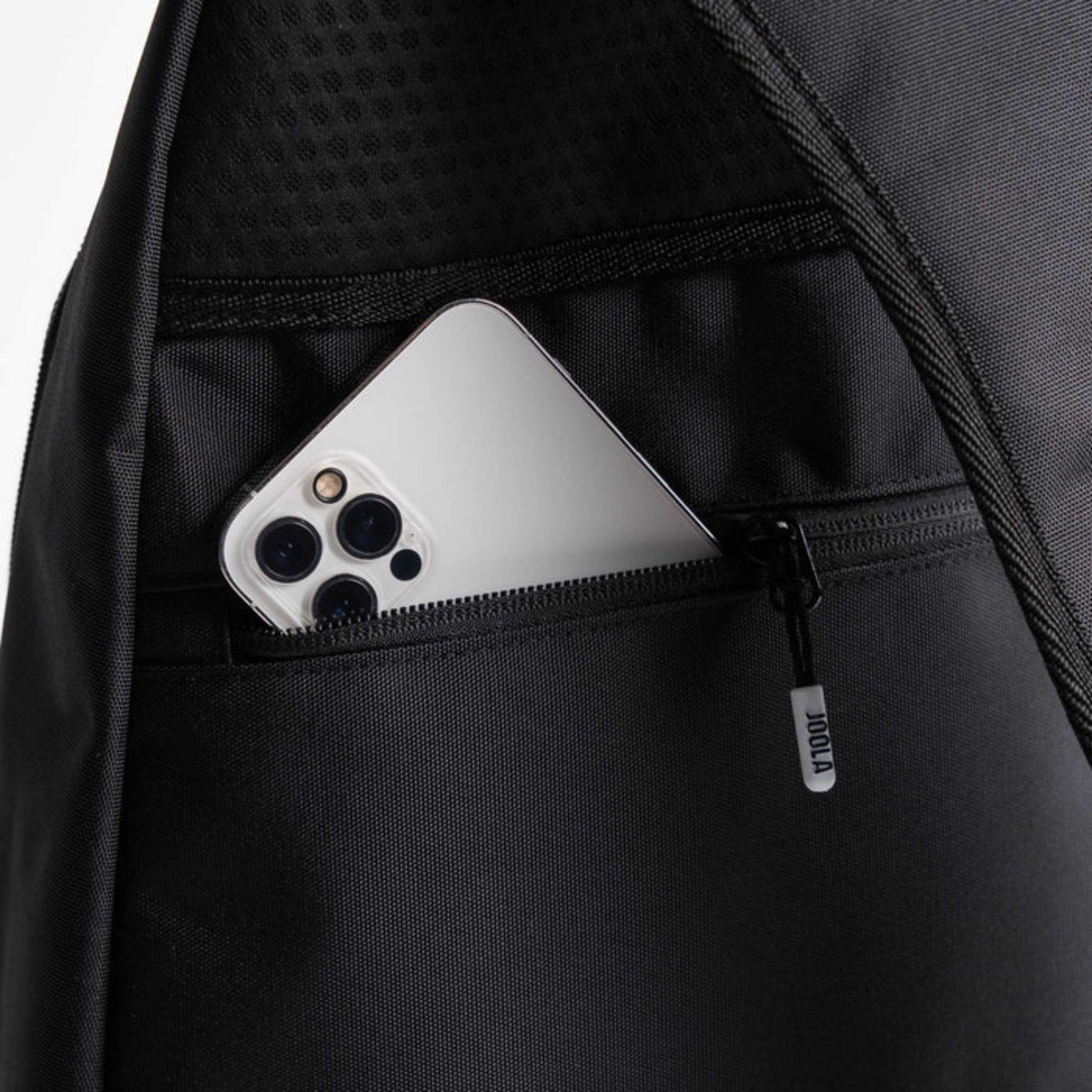 Black backpack with a pocket containing a silver phone, brand 'Vancrop' visible.
