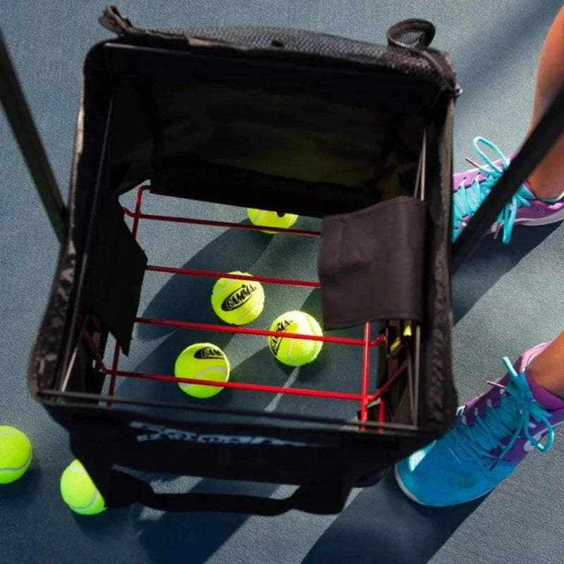 Portable ball hopper basket with fabric storage compartment, carry handles, and a standing frame for easy transport and access during practice.