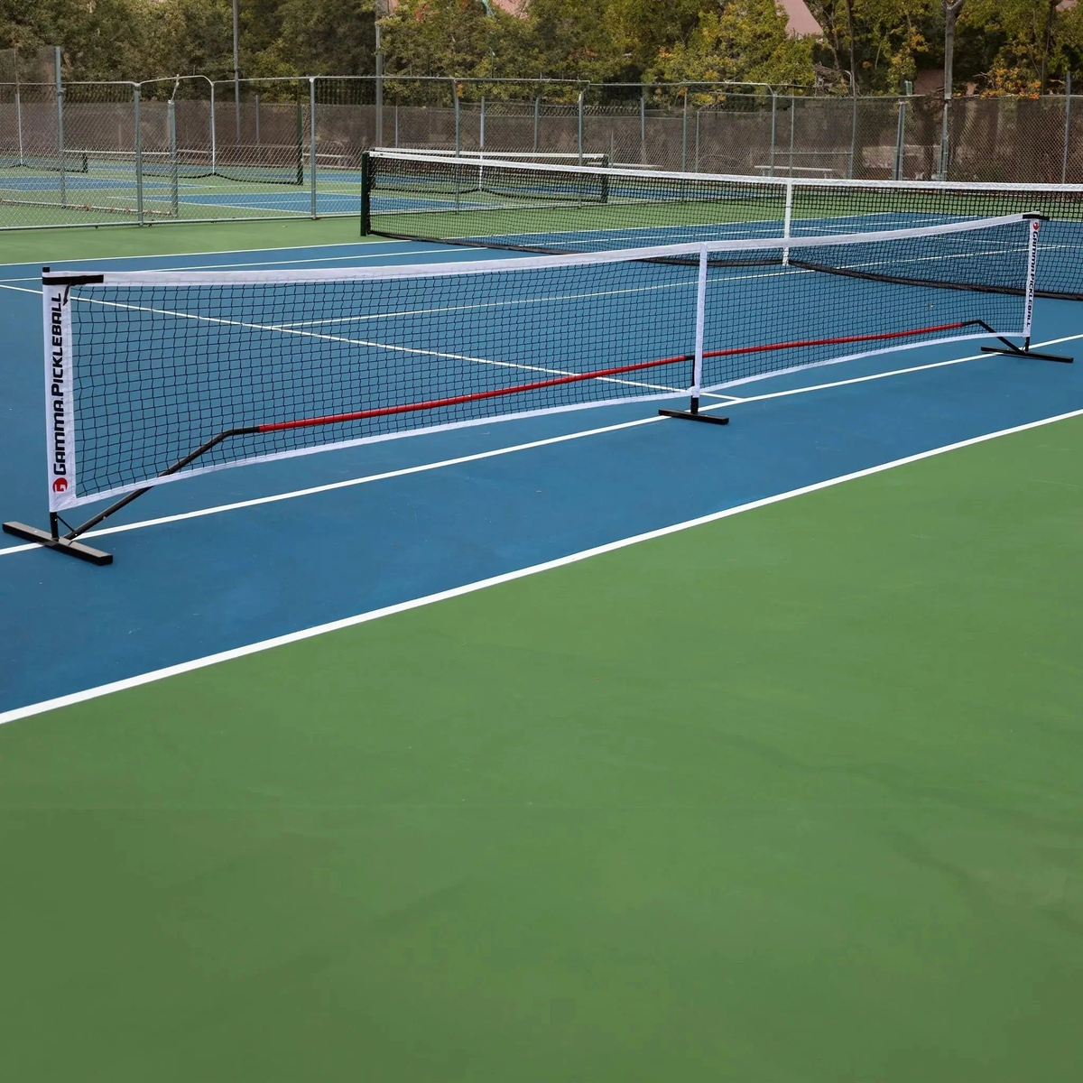Portable pickleball net system with mesh netting and a stable frame designed for easy setup on a court.