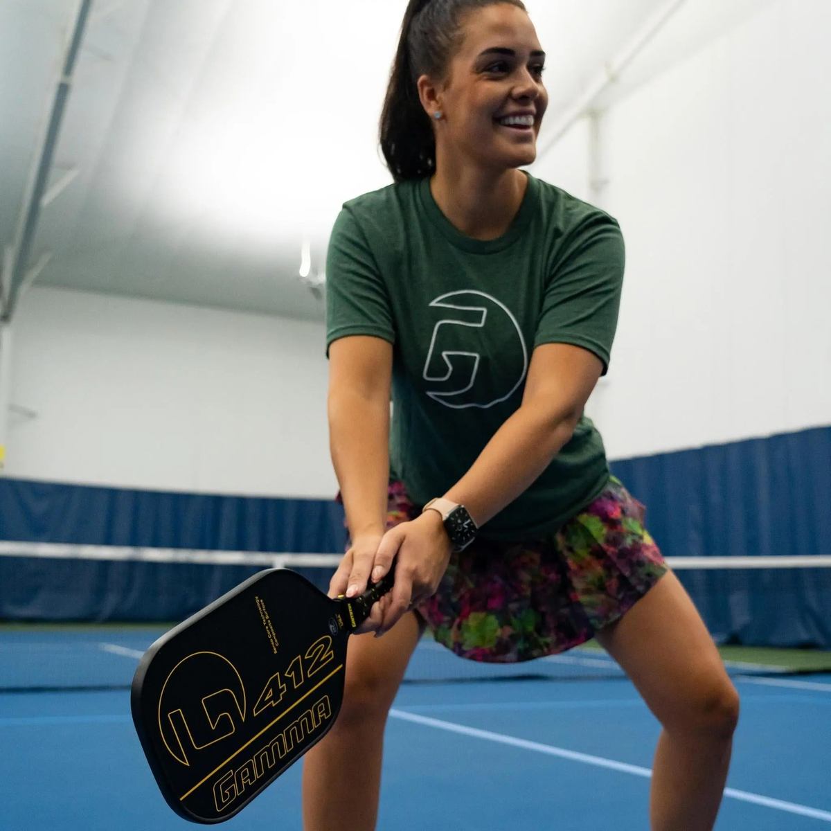 Pickleball paddle with a wide rectangular face, textured hitting surface, and cushioned grip handle featuring a bold graphic design on the front.