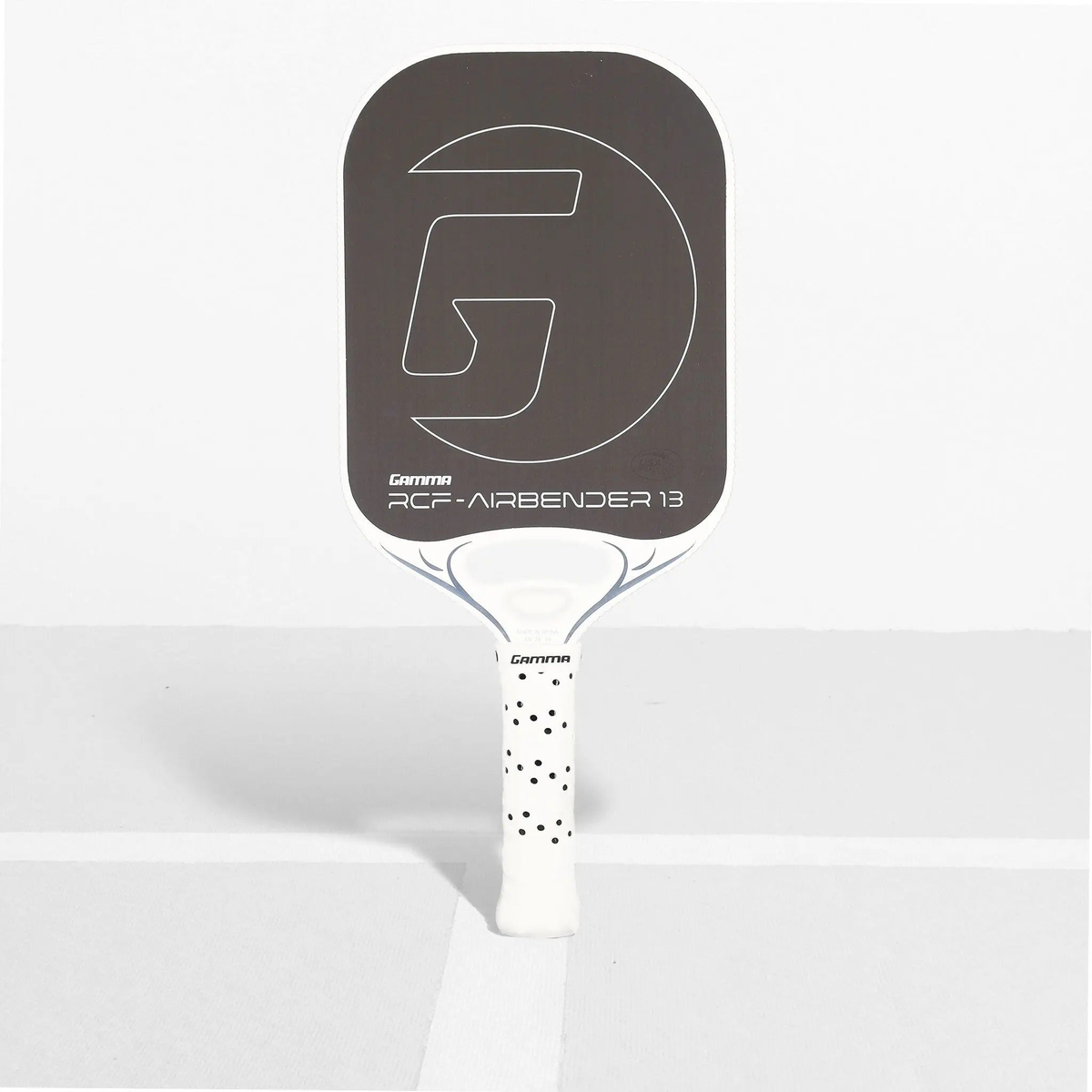 Pickleball paddle with a wide face design, textured hitting surface, and cushioned grip handle with perforations for improved control and comfort.