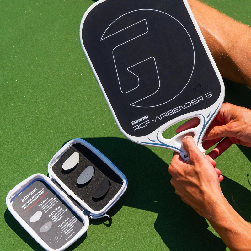 Pickleball paddle with a wide face design, textured hitting surface, and cushioned grip handle with perforations for improved control and comfort.