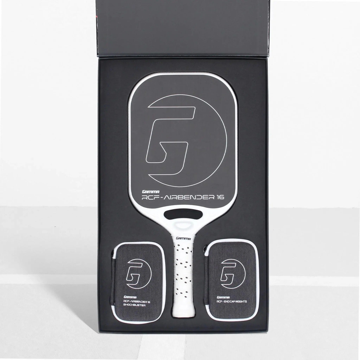 Pickleball paddle presented in a premium box set with a wide face design, cushioned grip handle, and included accessory pouches neatly arranged inside the packaging.