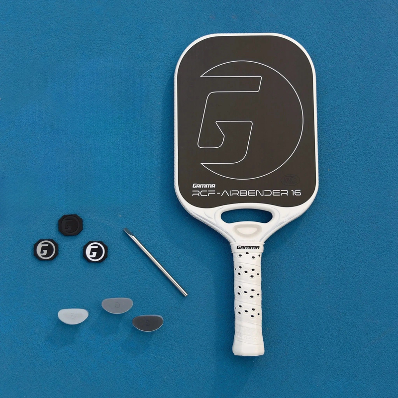 Pickleball paddle presented in a premium box set with a wide face design, cushioned grip handle, and included accessory pouches neatly arranged inside the packaging.