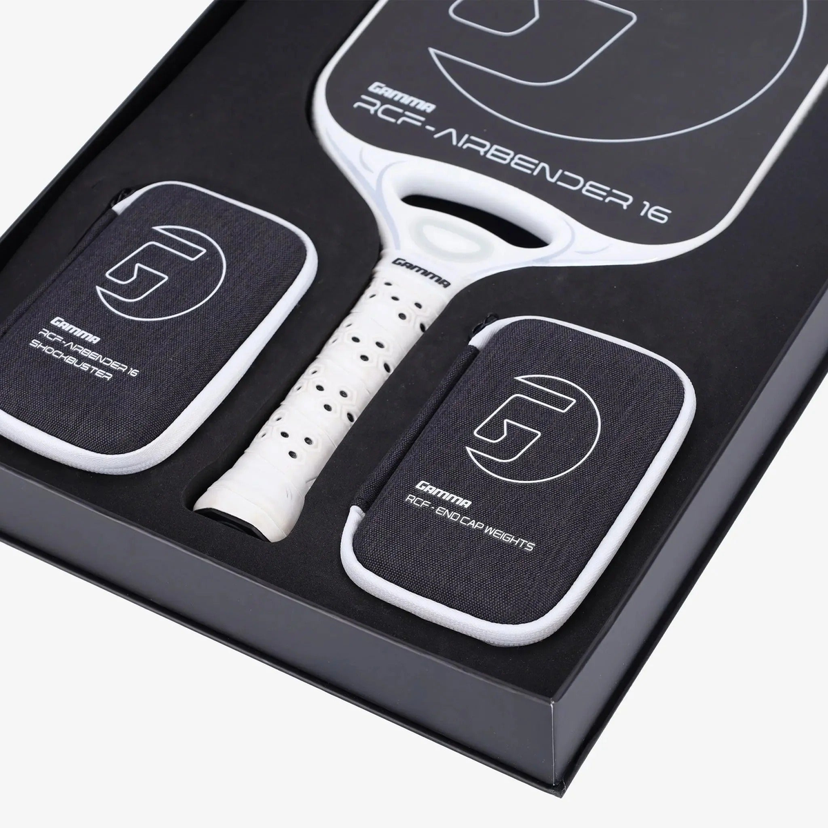 Pickleball paddle presented in a premium box set with a wide face design, cushioned grip handle, and included accessory pouches neatly arranged inside the packaging.