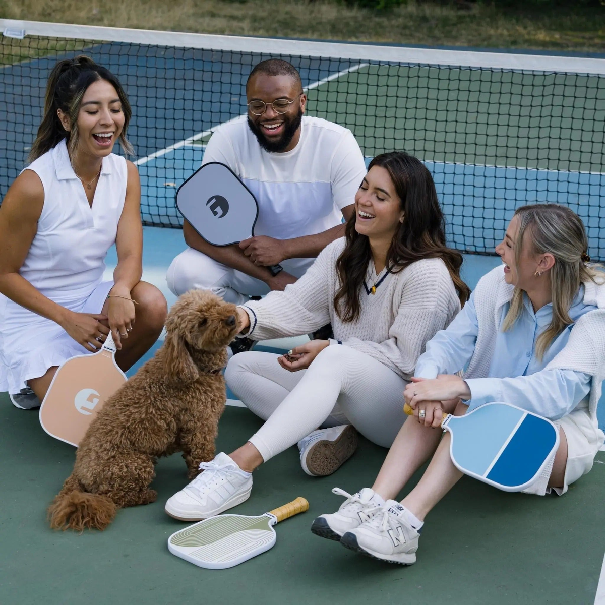 Pickleball paddle with a wide face, striped surface design, and cushioned grip handle for improved control and comfort.