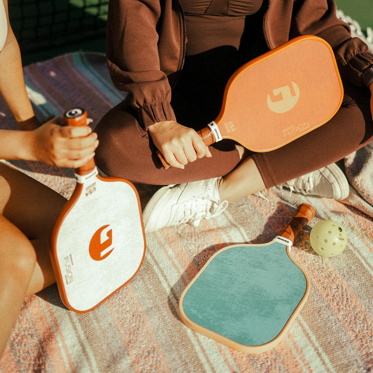Set of pickleball paddles with wide faces, textured surfaces, and cushioned grip handles designed for power and control.
