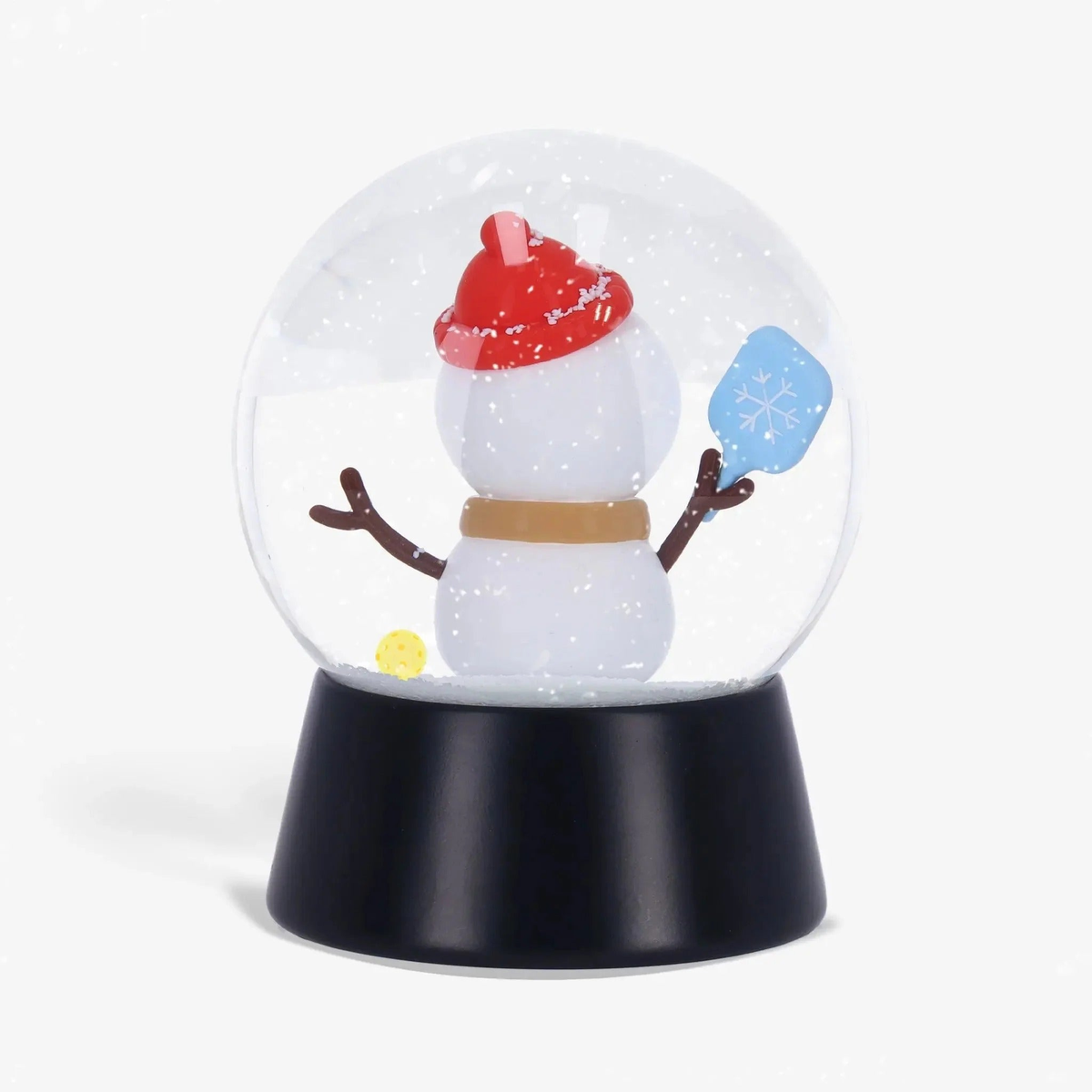 Snow globe featuring a snowman holding a paddle inside a clear dome with falling snow effect, mounted on a display base.