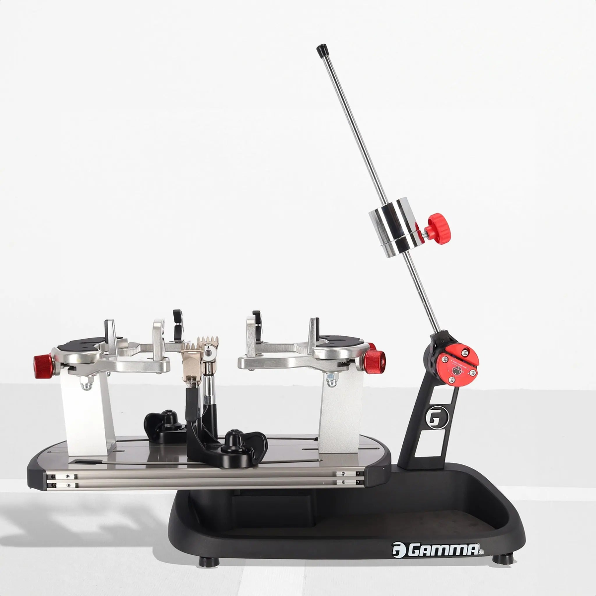 Manual drop weight stringing machine with a base platform, rotating mounting system, adjustable tension arm, and clamp mechanisms for securing and stringing racquets.