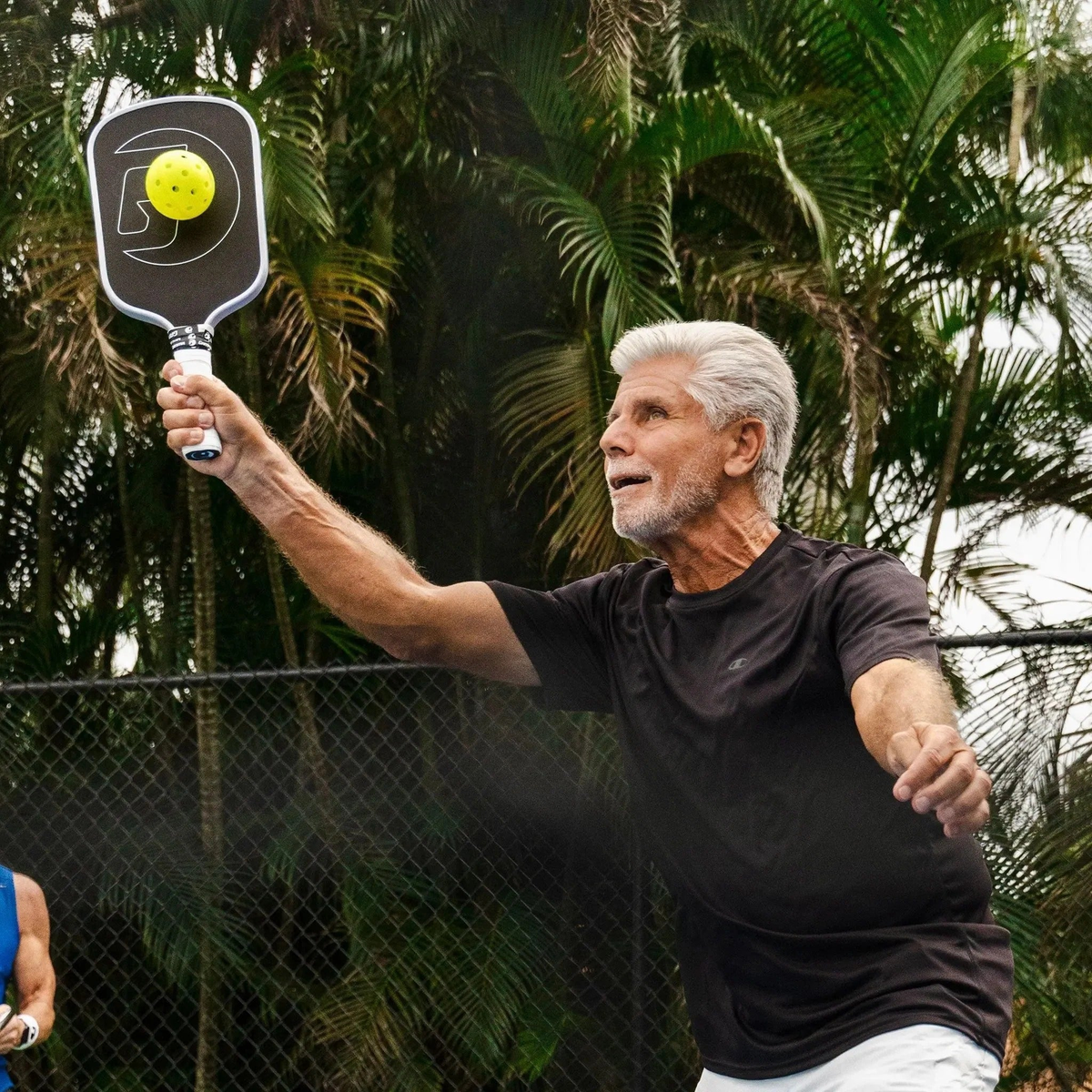 Pickleball paddle with a textured face, wide body shape, and cushioned grip handle designed for control and performance.