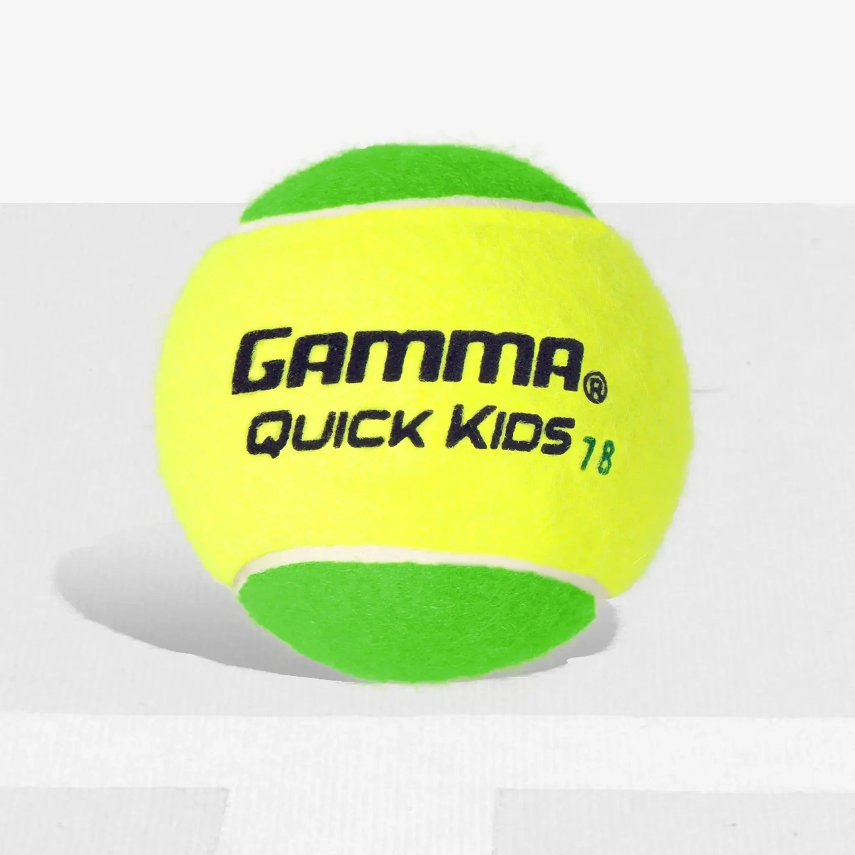 Youth training tennis ball designed for beginner players, featuring reduced compression for a slower bounce and easier control during practice.