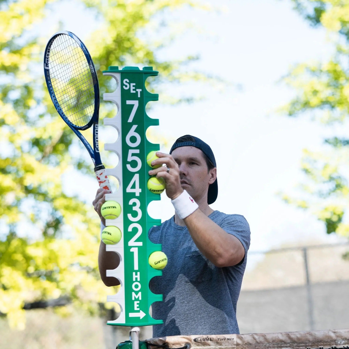 Portable scorekeeping post with rotating number panels and ball holders, designed for tracking game scores on court.