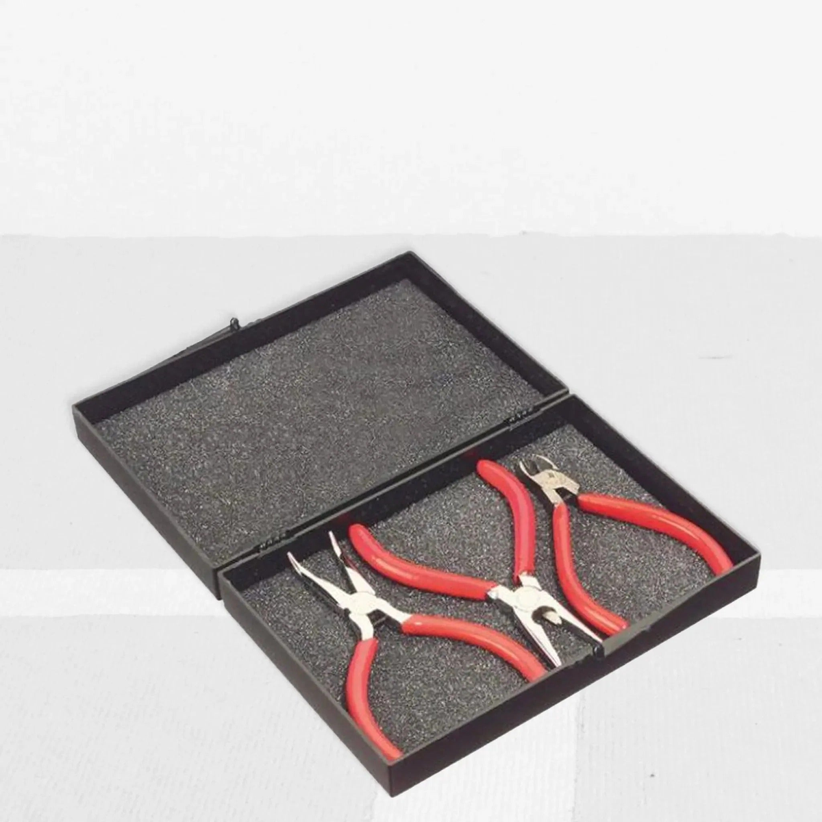 Tennis stringing starter tool kit set in a storage case, including multiple hand tools with cushioned handles arranged in a foam insert.