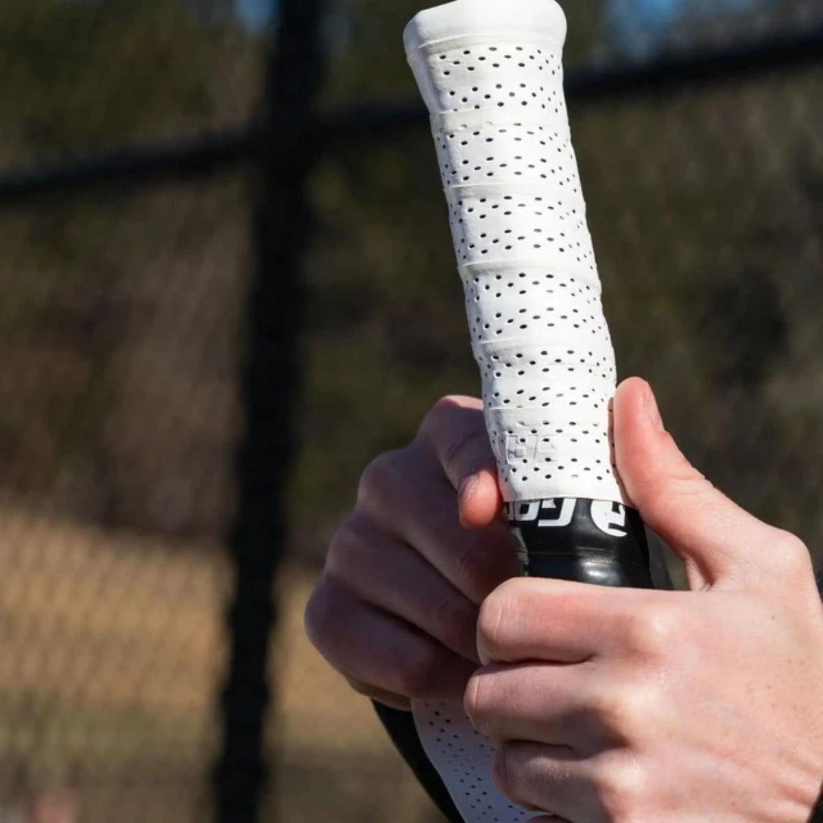 Tennis racket perforated overgrip pack with multiple grip wraps in retail packaging, designed for enhanced moisture absorption, traction, and durability.