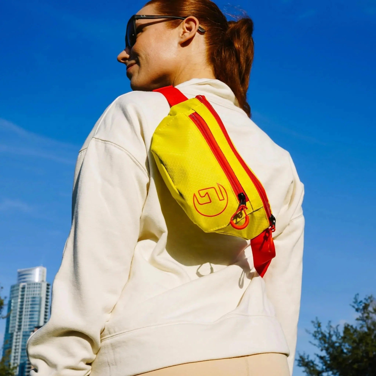 Sport fanny pack with adjustable strap and zippered compartments, designed for convenient storage of personal items during activities.