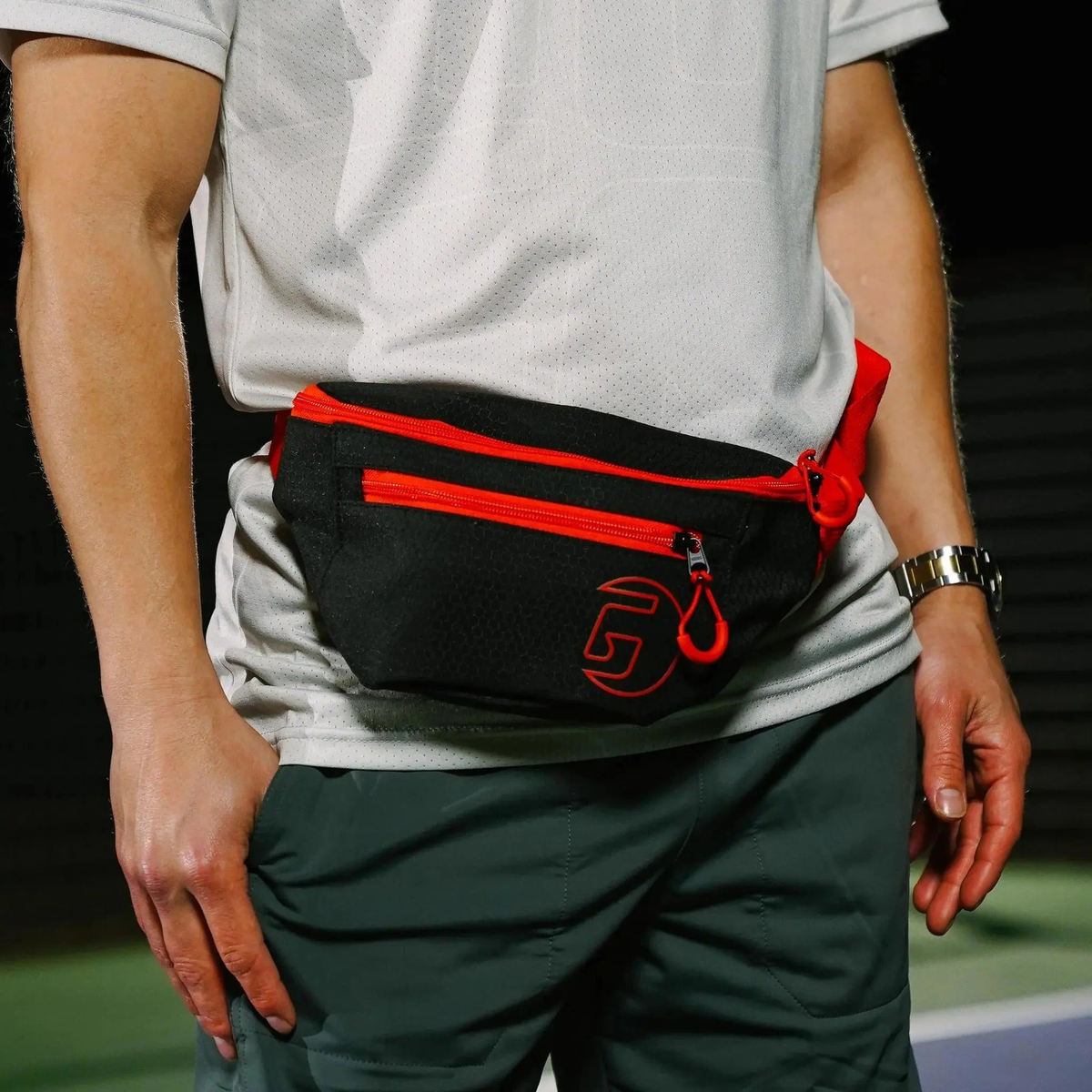 Sport fanny pack with adjustable strap and zippered compartments, designed for convenient storage of personal items during activities.