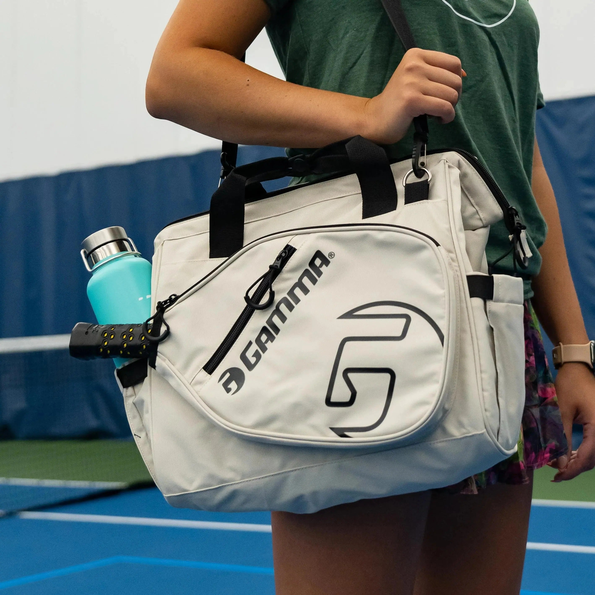Sport tote bag with carry handles and shoulder strap, featuring multiple zippered compartments and a side pocket for holding a water bottle or gear.