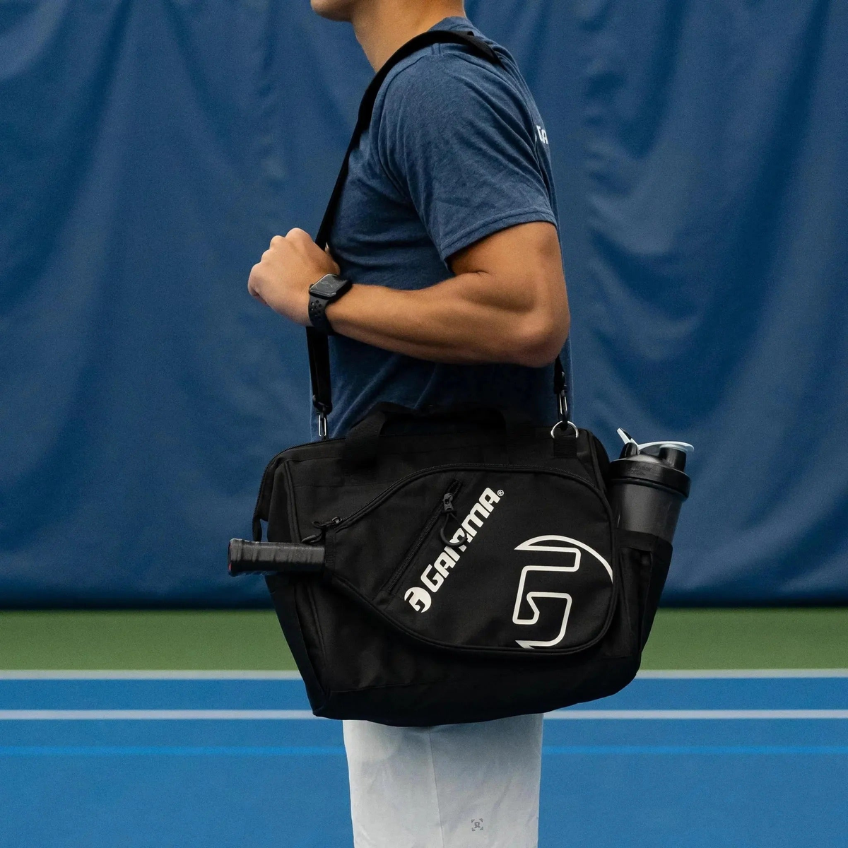 Sport tote bag with carry handles and shoulder strap, featuring multiple zippered compartments and a side pocket for holding a water bottle or gear.