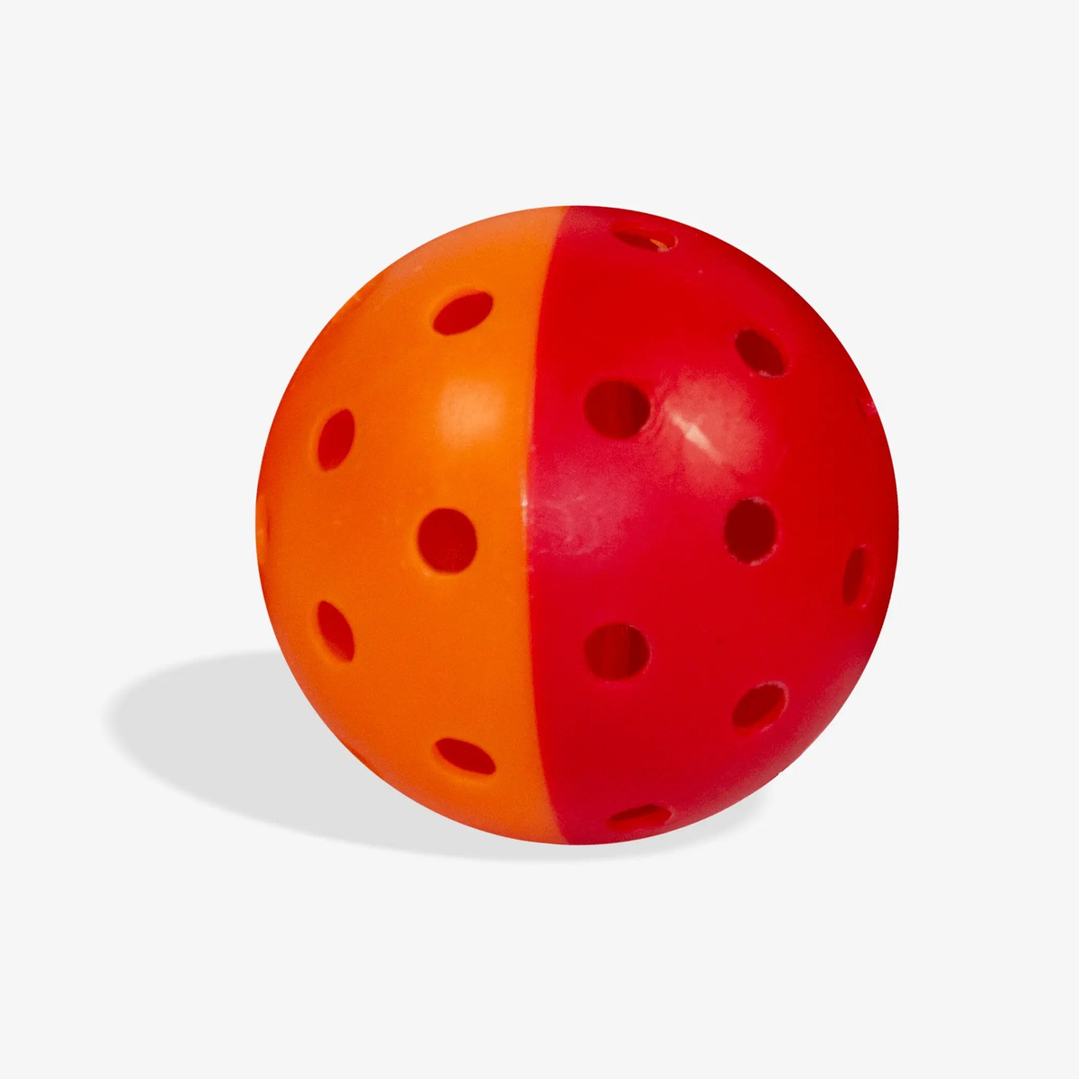 Outdoor pickleball with a two-tone design and evenly spaced holes, designed for training and practice play.