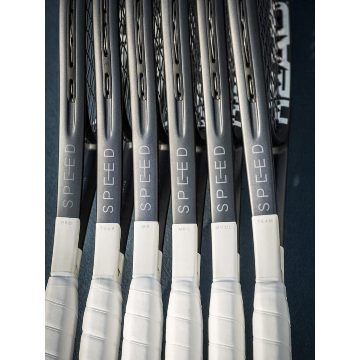 Close-up of multiple HEAD Speed tennis racquets lined up, showing PRO, TOUR, MP, MPL, MP L, and TEAM models on handles.