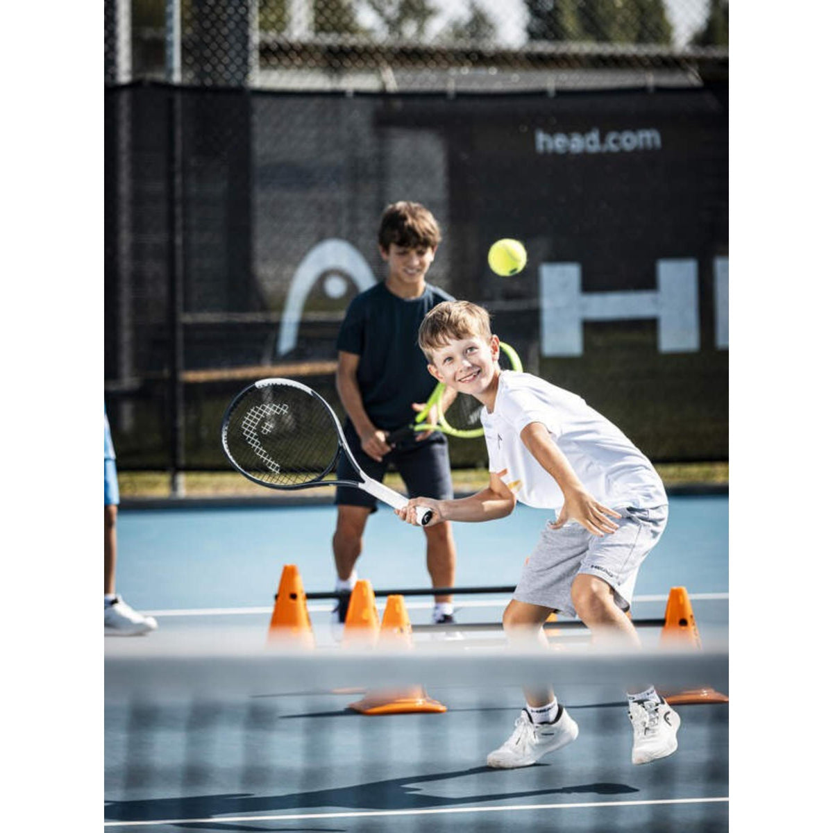 Young boy hitting tennis ball with HEAD Speed Jr. 2026 racquet during junior tennis practice.