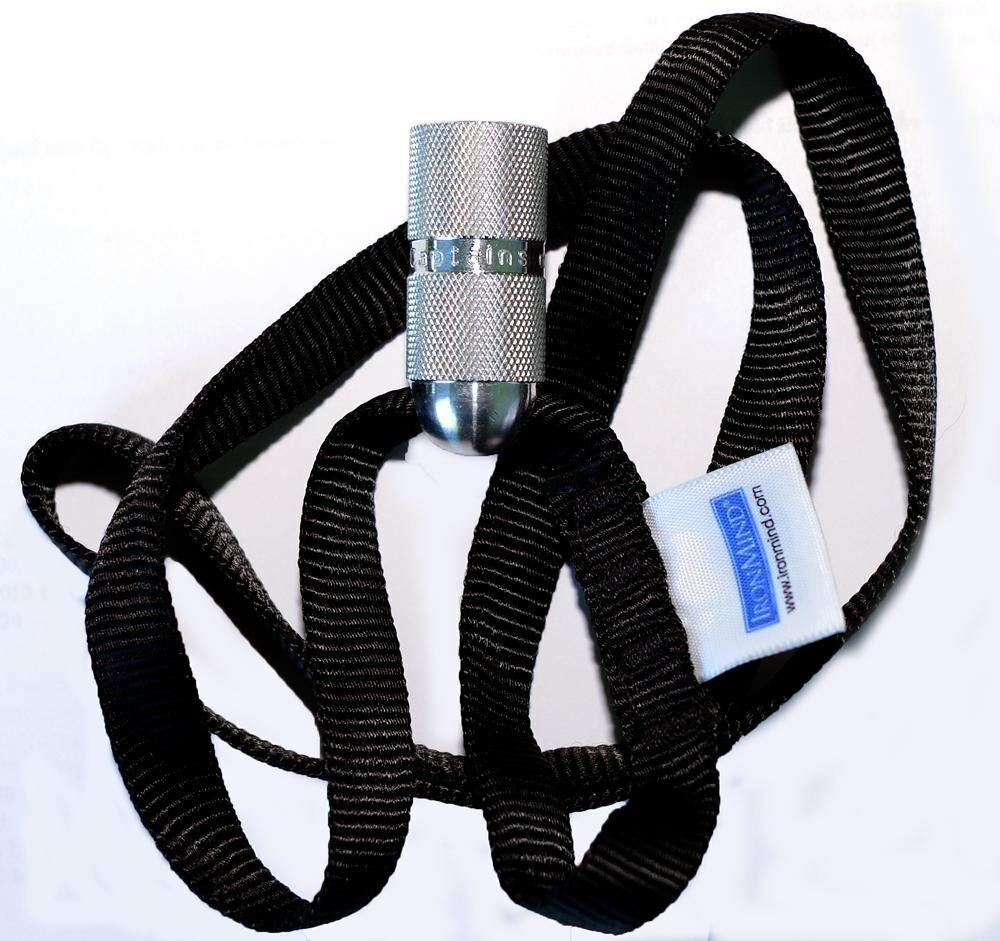 A silver bullet gripper from IronMind attached to a black strap, designed for hand strength training.